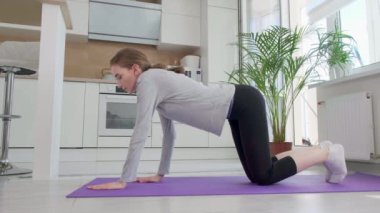 Genç, güzel, sportif bir kadın evde kalas ütülüyor. Sağlıklı yaşam tarzı.