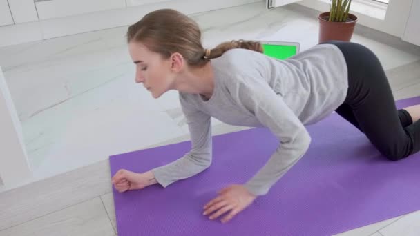 Спортивная молодая здоровая женщина делает упражнения на доске дома на спортивном коврике. — стоковое видео