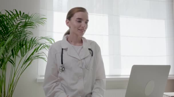 Doutor mulher em um vestido médico aconselhar um cliente, paciente on-line. 4k vídeo. — Vídeo de Stock