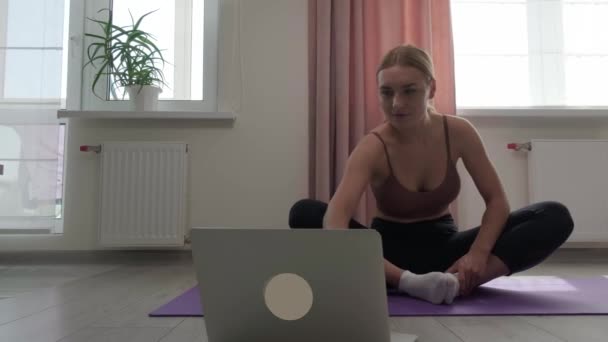 Mujer aprende yoga en línea. Ver video tutoriales. Concepto deportivo y recreativo. — Vídeo de stock
