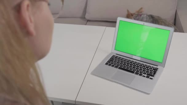 The girl sits with her back and looks into the laptop monitor. — Stock Video