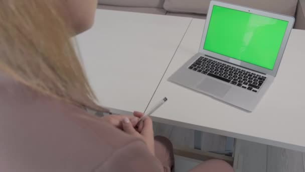 Det finns en bärbar dator med en grön skärm på bordet, en plats för reklam. — Stockvideo