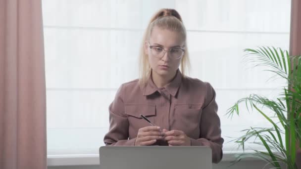 Zakenvrouw kijkt zorgvuldig naar de laptop webcam. Videoconferentie. — Stockvideo