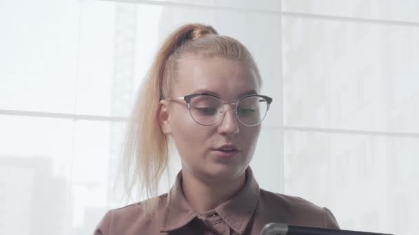 Блондинка в окулярах вчитель спілкується за допомогою відеозв'язку . — стокове відео