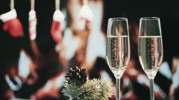 Firar jul och nyår. Två glas lekvin med bubblor. — Stockvideo