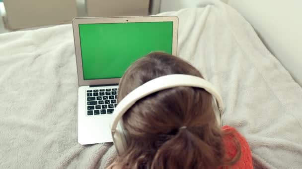 Écolière fille tourné son dos à nous et regarde dans l "écran de l" ordinateur portable. — Video
