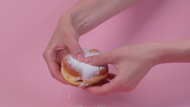 Deux mains cassent un beignet rond frais avec remplissage. Lait concentré à l'intérieur. — Video