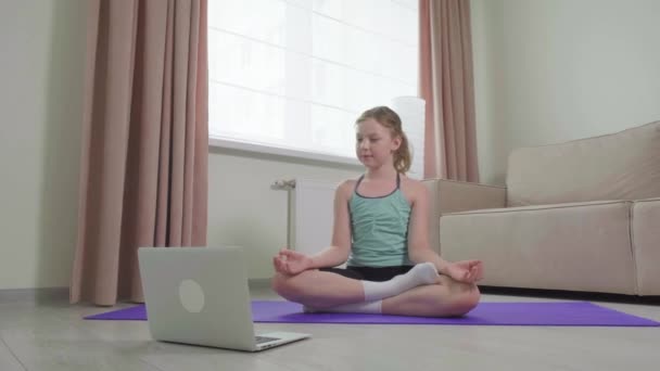 La chica practica yoga en casa y realiza la posición de loto. Deportes en casa. — Vídeos de Stock