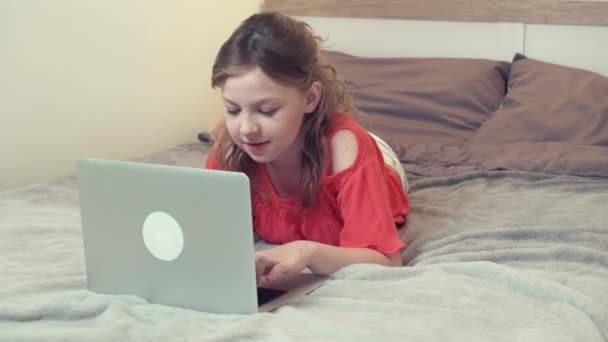 Jovem menina bonita deitada na cama em casa se comunica em redes sociais. — Vídeo de Stock