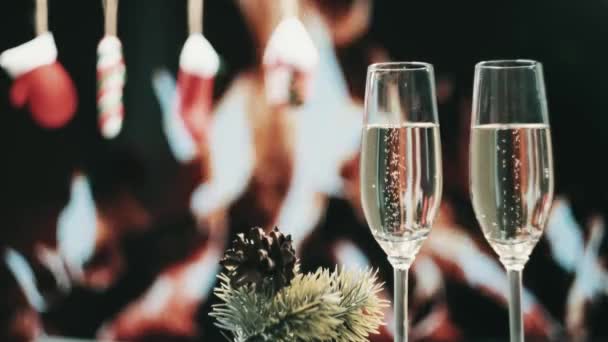 Celebrando o Natal e o Ano Novo. Bolhas de champanhe em dois copos. — Vídeo de Stock