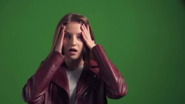 Uzun saçlı korkmuş bir kız başını tutup etrafına bakıyor. İnsani duygu.