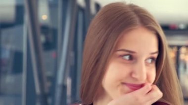 Mutlu genç bir kadın kameraya doğru yürür ve bakar. Güzel gülümseme.