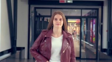 Bir kadın güzel saçlarını düzleştirir ve ileri doğru yürür. Kameraya bak..