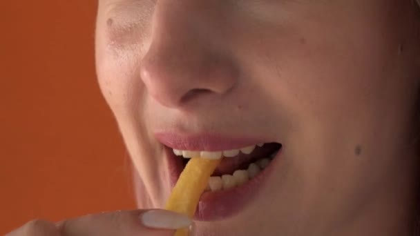 Bibir seorang wanita cantik muda yang makan kentang goreng. Menikmati makanan. — Stok Video