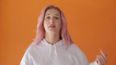Kadın ellerini sallıyor, arkadaşını arıyor. Pembe saç. İnsan duyguları.
