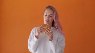 Lezzetli burger yemek isteyen genç bir kadın. Kız fast food yiyor..