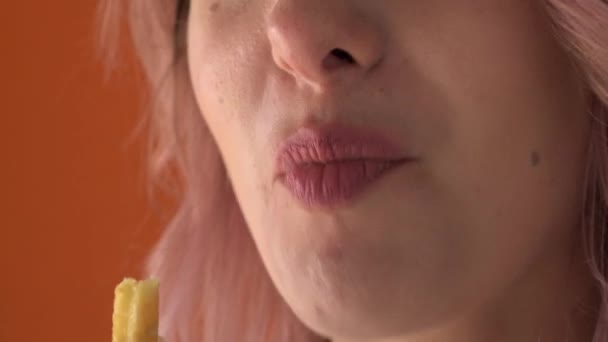 Les lèvres d'une jeune femme qui mange une pomme de terre frite. Appréciation de la nourriture. — Video