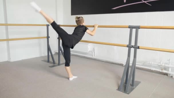 Handsome blond guy performs ballet exercises, kick back. Dance school training. — Stock Video