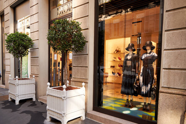 Contemporary showcase of a Dior store. Clothing store. Mannequins in fashionable beautiful dresses. Milan Italy 08.2020