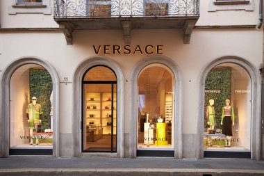 Versace mağazasının aydınlatılmış vitrini. Mağazanın ön kapısı. İtalya 08.2020