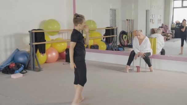Молодая эмоциональная женщина тренер присматривает за студенткой, которая танцует балет. — стоковое видео
