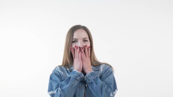 A beautiful blonde girl smiles, laughs and covers her face with her hands. — Stock Video