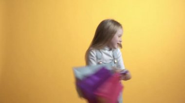 Güzel bir kız alışveriş torbalarıyla kendi etrafında dönüyor..