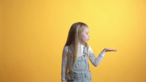 Ένα κορίτσι δείχνει ένα χέρι στο οποίο δεν υπάρχει τίποτα και δείχνει έναν αντίχειρα επάνω χειρονομία. — Αρχείο Βίντεο