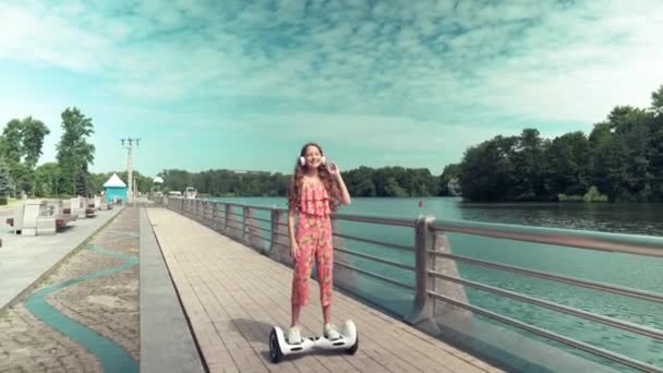 Una bella ragazza con i capelli lunghi sta cavalcando un hoverboard. — Video Stock