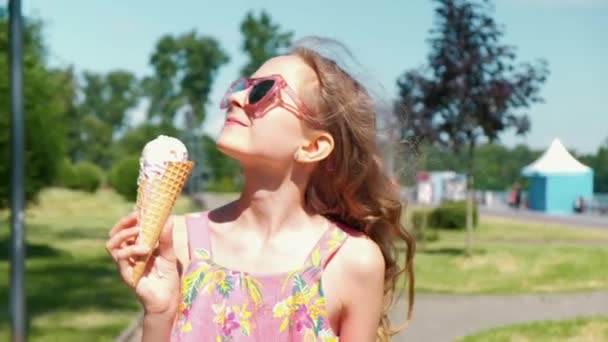 Ragazza felice in occhiali da sole mangia gelato e va avanti. Cavalcare un hoverboard. — Video Stock