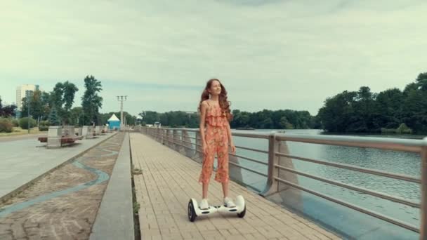 Hoverboard équitation dans le parc. Belle fille mince avec les cheveux longs. — Video