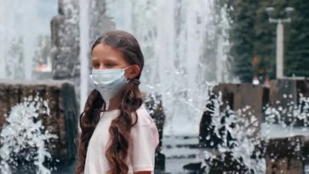 Summer park. A pretty girl in a medical mask during a pandemic. — Stock Video
