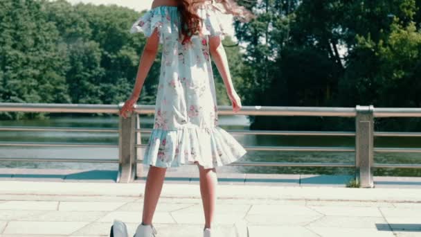 Una ragazza cavalca un hoverboard in cerchio. Riposo in un giorno di riposo nel parco fuori. — Video Stock