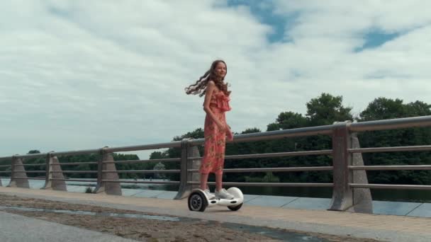 Slow motion av en tjej som kör en gyro scooter. Åker runt honom. — Stockvideo