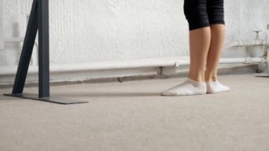 Bacakları yakın çekim, egzersiz, plie poz. Beyaz çoraplı bacaklar..