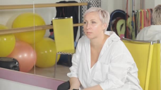 Jeune femme formatrice observe les élèves assis sur une chaise dans la salle de gym. — Video