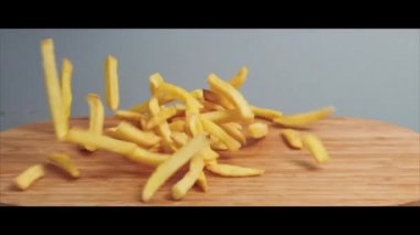 Düşen yiyecekler, patates kızartmaları, hamburgerler ahşap tahtaya yavaşça vuruyor..