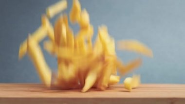 Altın patates kızartması ve bir hamburger tahtada tepeden tırnağa düşüyor. Yavaş çekim