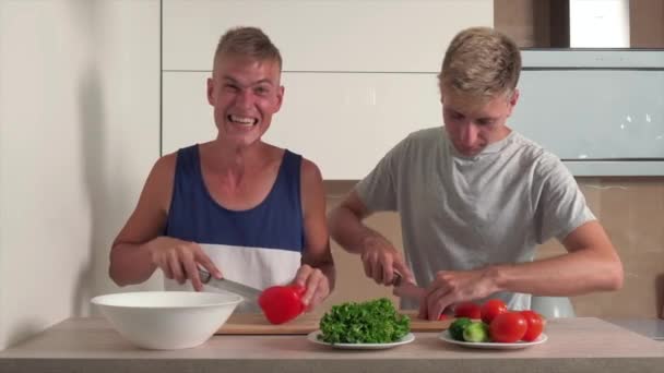 Deux beaux gays préparent le petit déjeuner dans une cuisine lumineuse. — Video