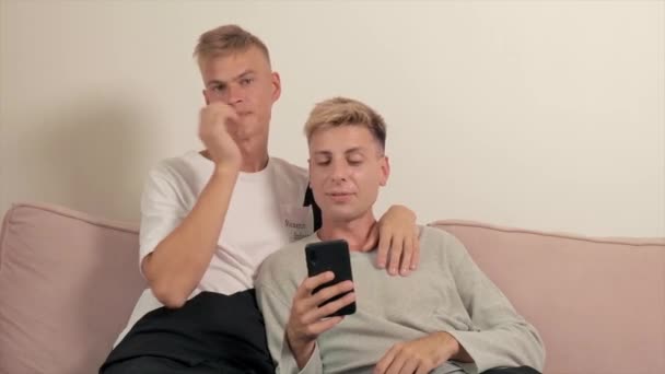 게이 커플의 비디오가 리아를 소파에 묶고 있어요. 두 남자가 친구를 사랑하네. — 비디오