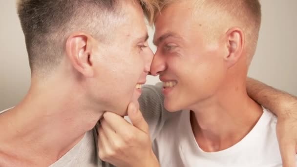 Homosexuální dvojice, sedící bok po boku a líbající se. Polib dva kluky. — Stock video