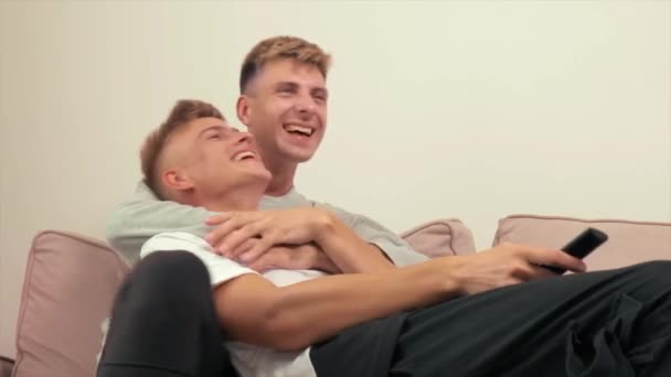 Pareja gay pasar tiempo juntos en casa en el sofá mentira y risa. Pareja LGBT. — Vídeos de Stock