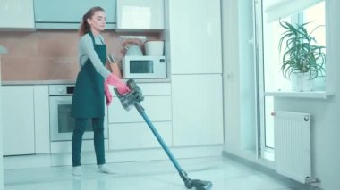 Güzel genç bayan mutfağı süpürüyor. Ev işleri..