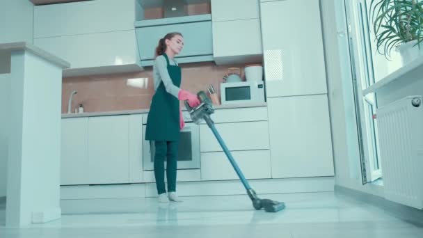 Hermosa joven está haciendo limpieza en una cocina luminosa. — Vídeos de Stock