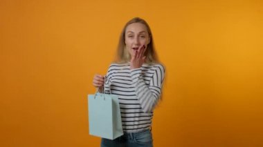 Şaşkın genç kadın paketleri, bayramlarda hediyeleri, doğum günlerini elinde tutuyor..