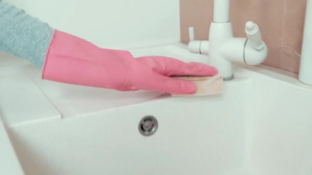 De meisjes handen in latex handschoenen wassen de gootsteen met een reinigingsspons. — Stockvideo