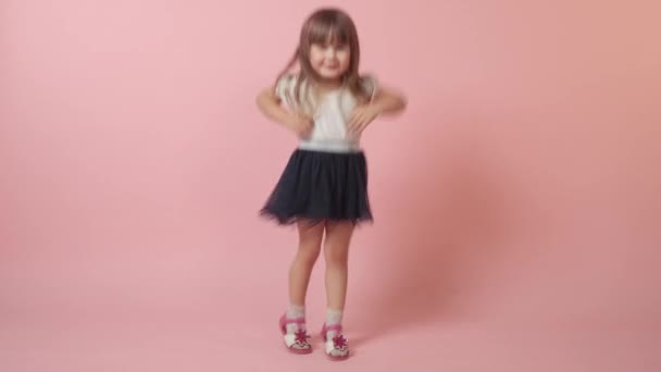 A cute little girl jumping, indulging and laughing. Beautiful festive outfit. — Stock Video