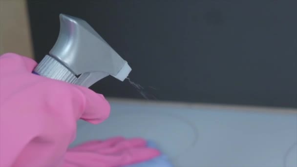 Hände in rosa Latexhandschuhen sprühen das Produkt auf den Herd. — Stockvideo