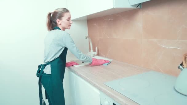 Gadis itu adalah seorang pembersih profesional melakukan pembersihan di dapur, dalam sarung tangan. — Stok Video