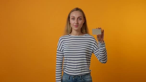 年轻女子展示空白的灰色卡片,显示拇指垂下的手势.4K视频. — 图库视频影像
